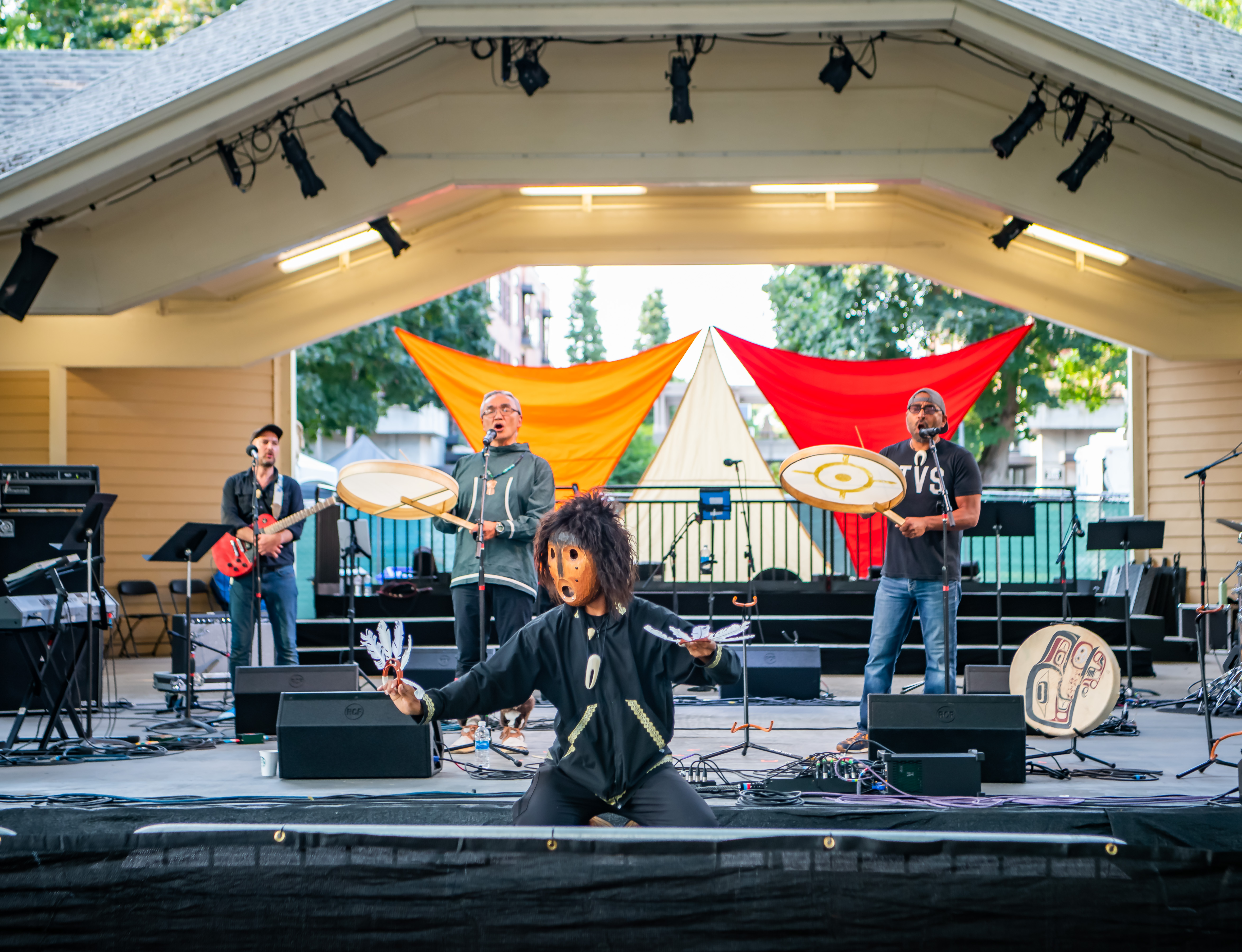 Musicians in masks on stage at outdoor festival