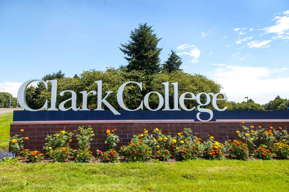 Clark College sign with flowers planted in front