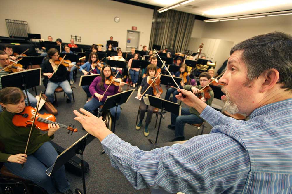 An orchestra professor conducting in class.