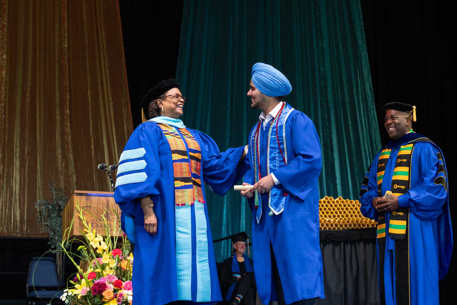 Gurraj Singh Dhami, Clark College's ASCC President, with Dr. Edwards on stage.