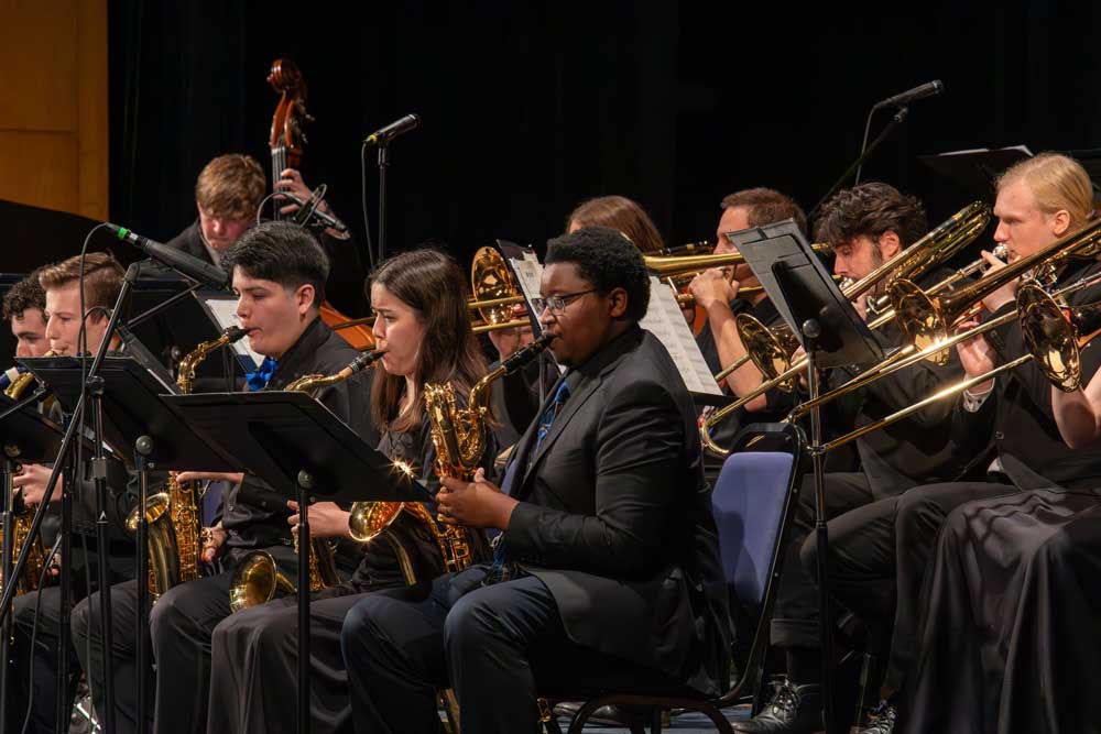 A group of students performing on stage during a jazz band concert.