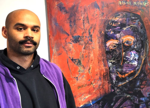 A person looking directly at the camera with a painting positioned beside them.