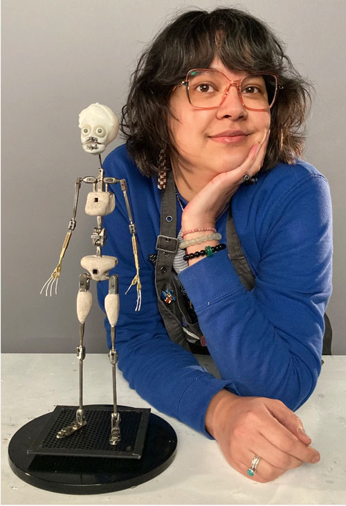A person posing for a photo beside a full-body skeleton model