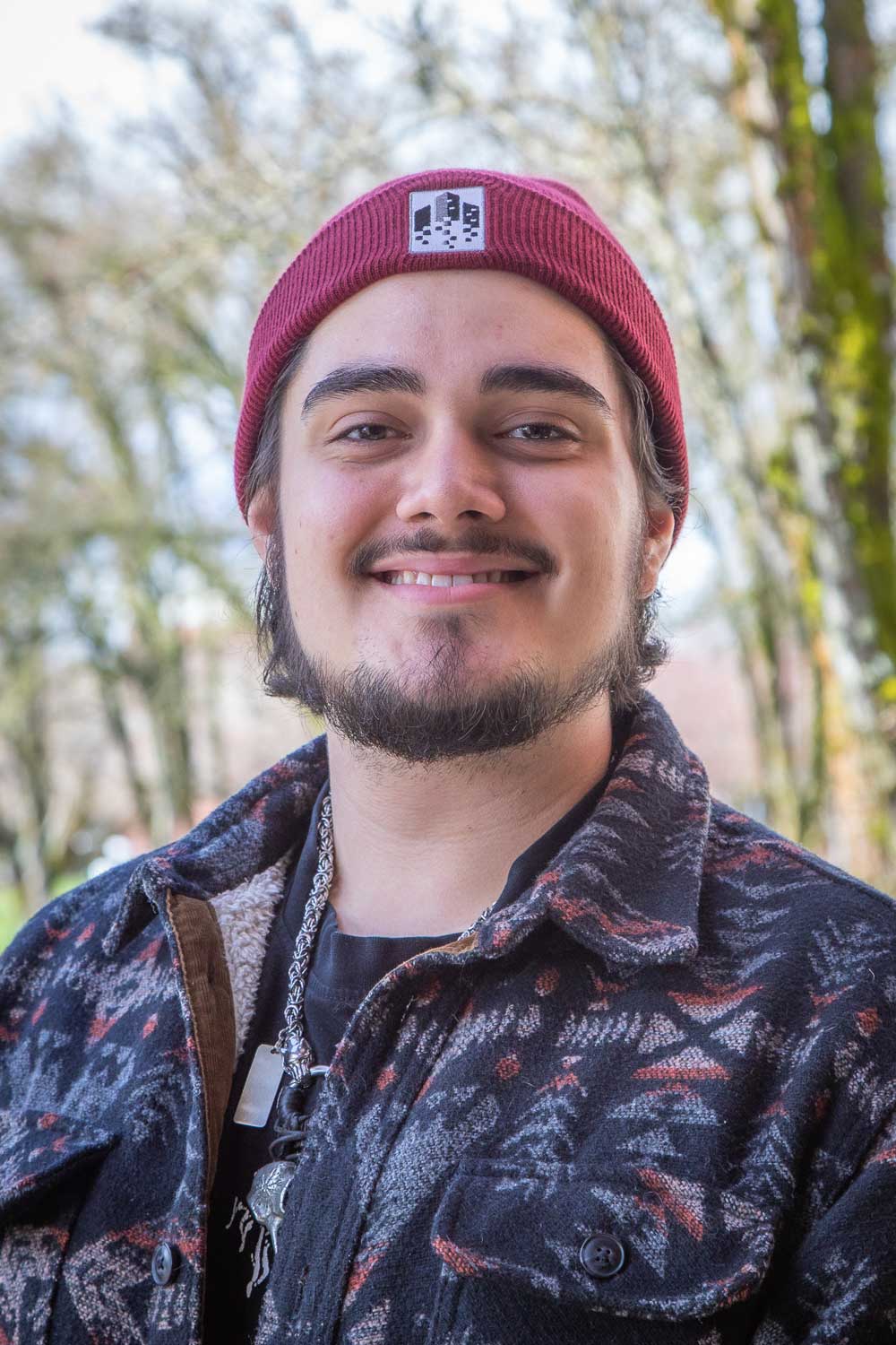 Headshot of a student, Seth Stigall Barranco, smiling wearing a beanie hat.