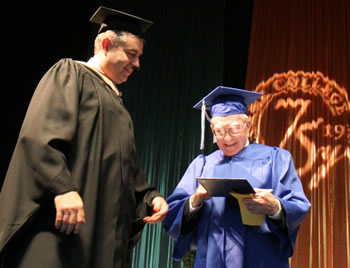 Clark College President Robert K. Knight presents a diploma to graduate Wilbert Kalmbach