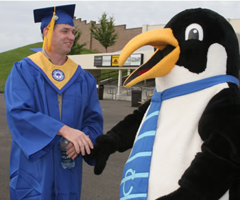 A 2007 graduate is congratulated by Clark mascot Oswald